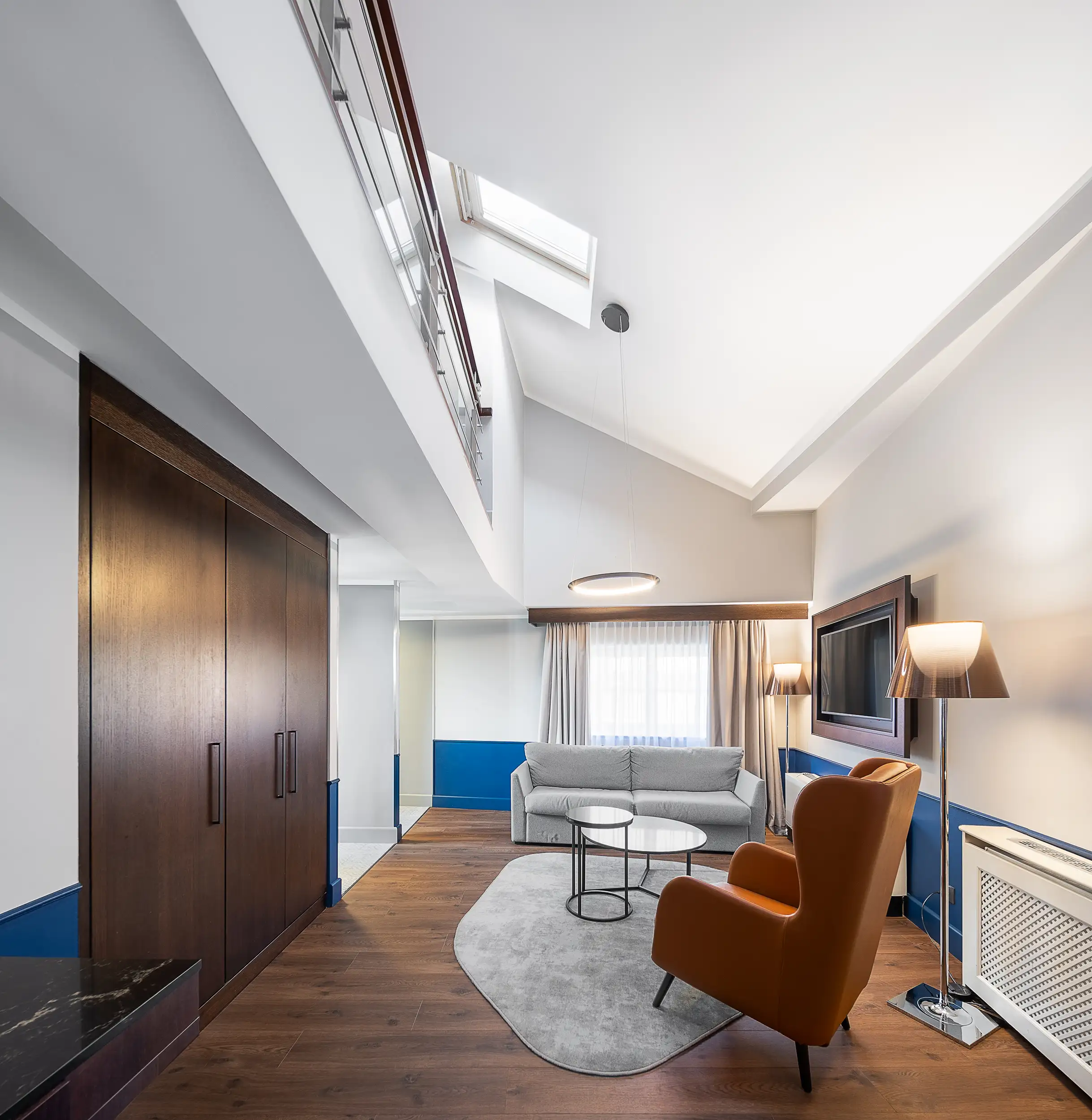 Großzügiger Penthouse Wohnbereich im Radisson Blu Prague mit Sofa, Sesseln, Dachfenstern und moderner Galerieebene