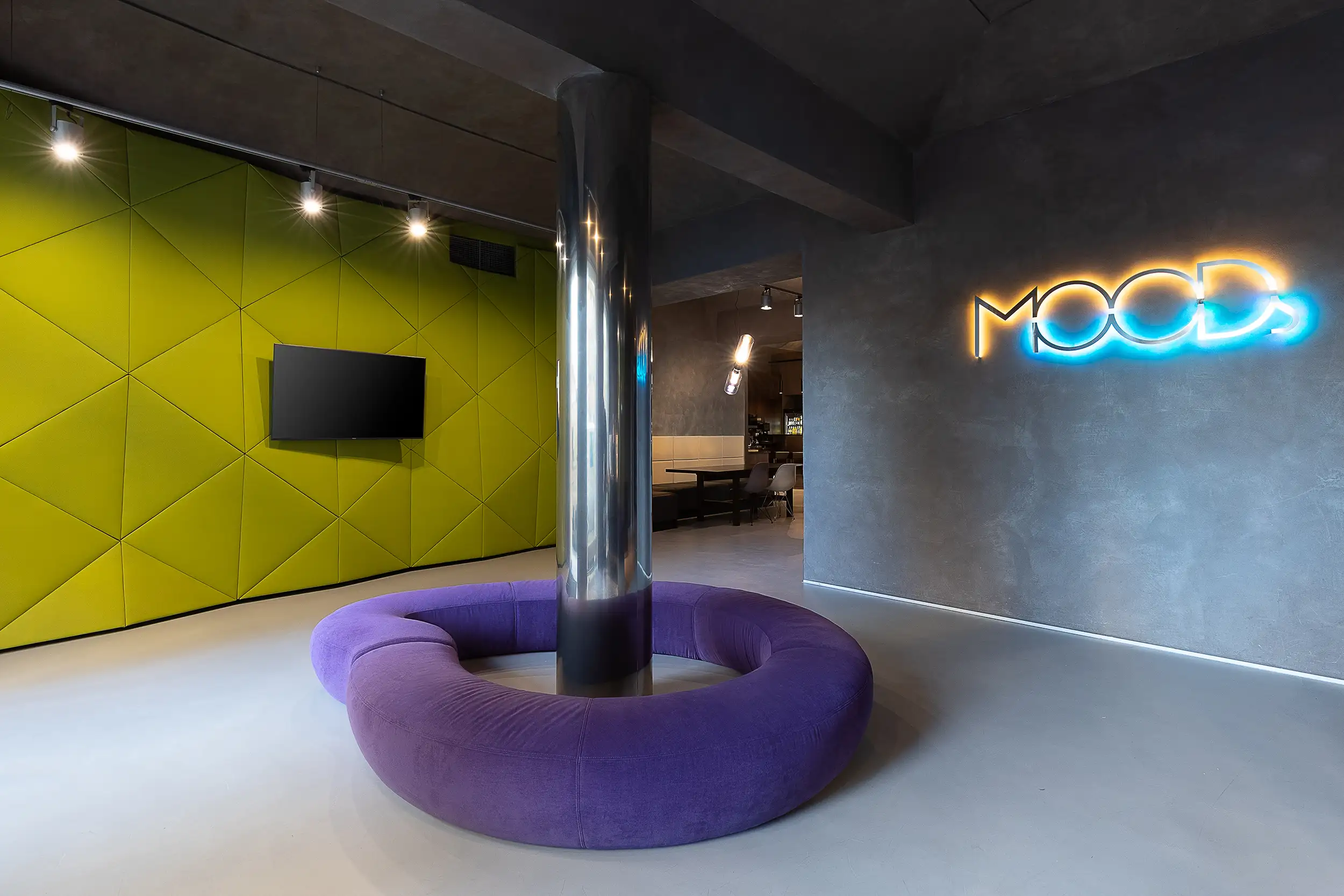 Lobbybereich des Hotel MOODs Boutique Prag mit geometrischer Wandgestaltung, grünem Akzentbereich und zentralem Loungebereich.