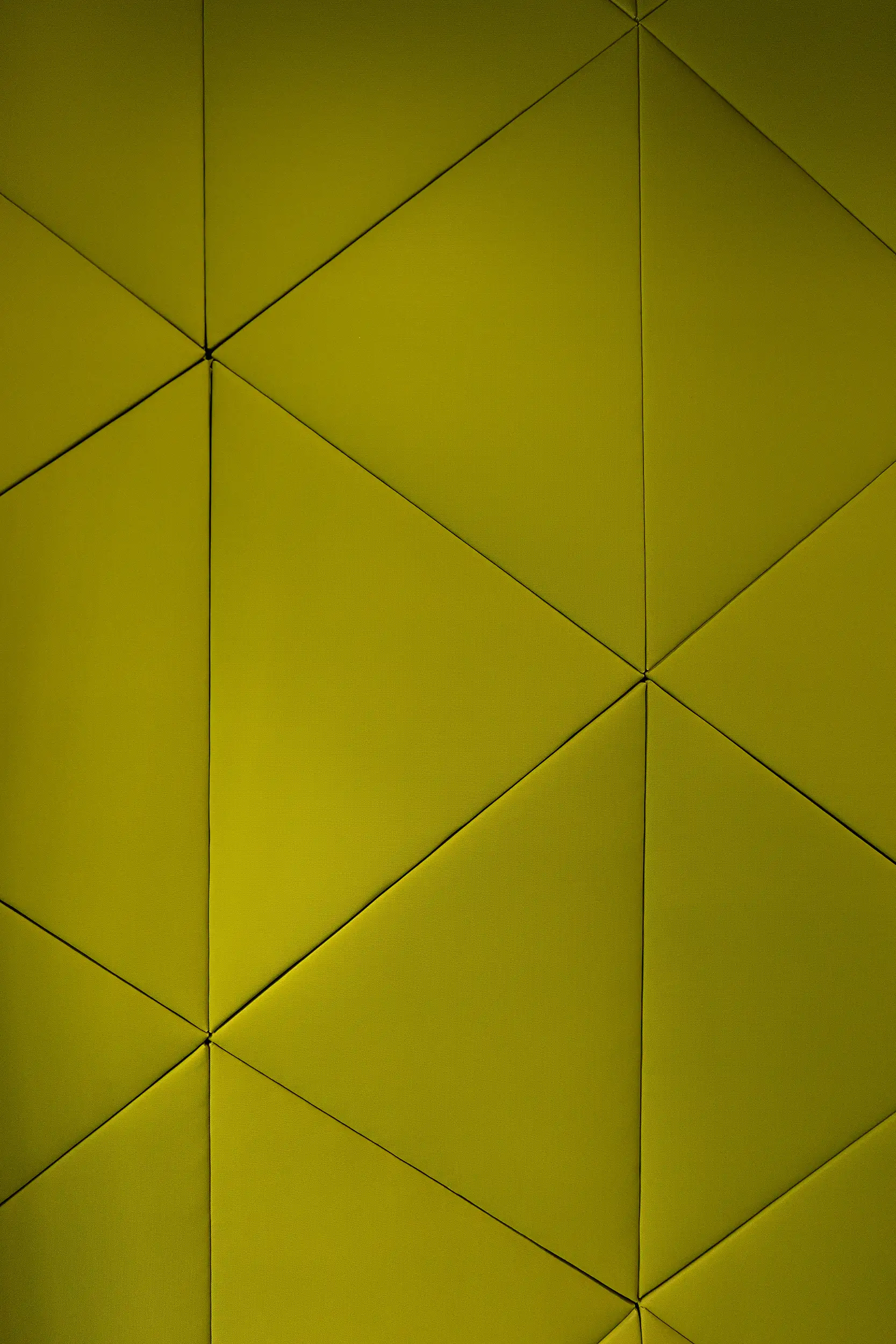 Detail der geometrischen Wandverkleidung mit dreidimensionalem Paneeldesign in kräftigem Grün.