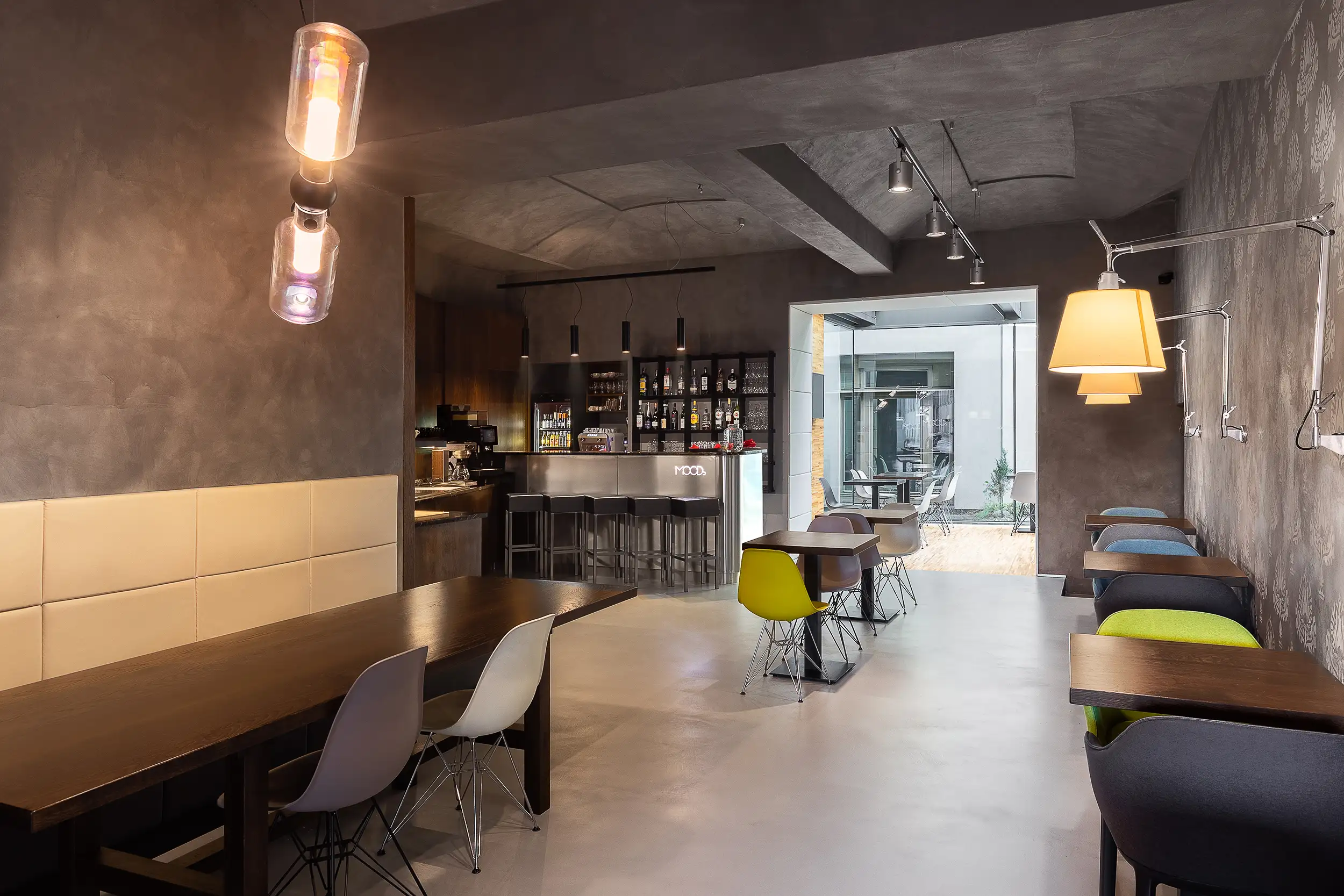 Frühstücksraum mit Buffet und Barbereich im Hotel MOODs Boutique Prag sowie Blick in die angrenzende Wintergarten-Sitzlounge.