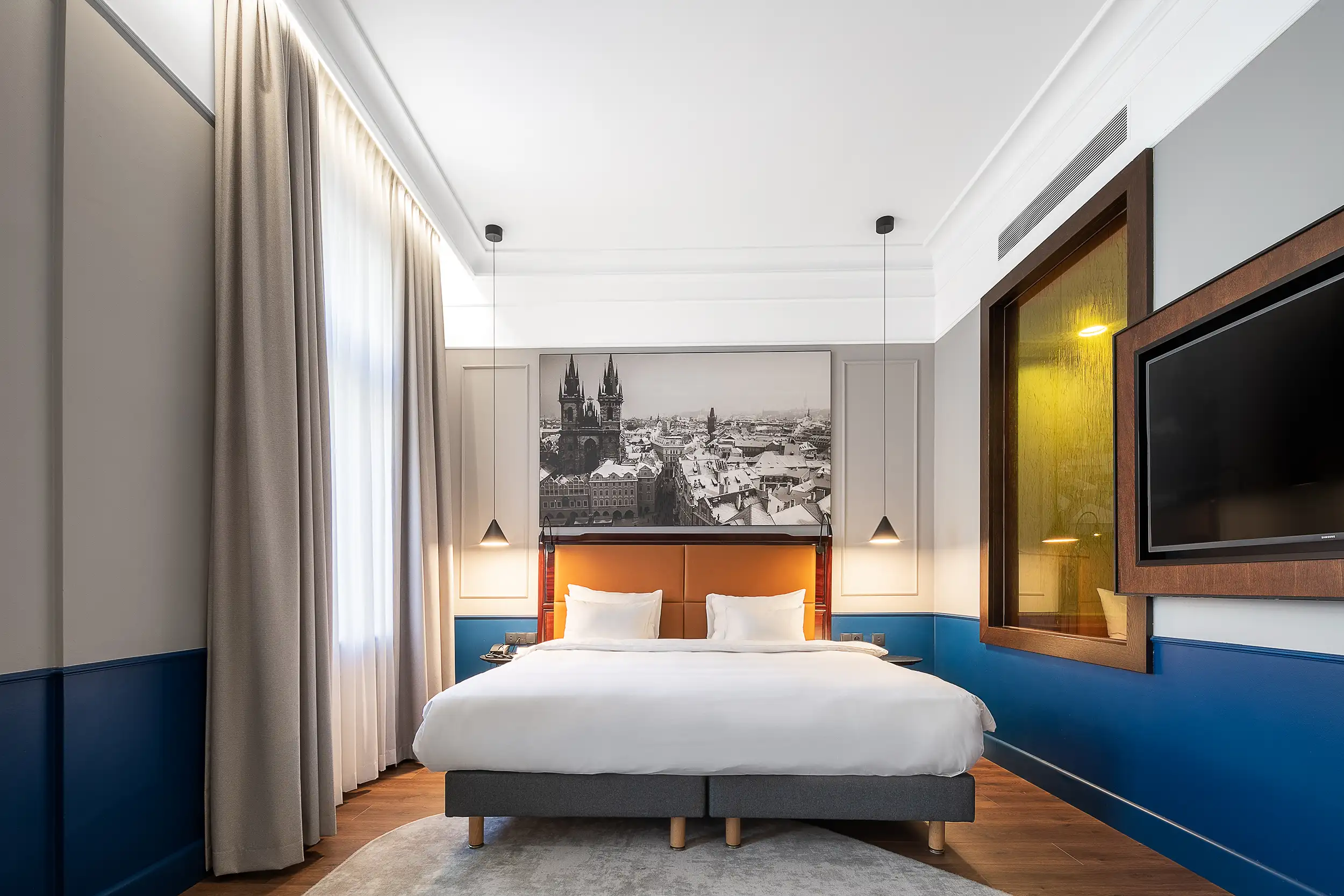 Hotelfotografie der Junior Suite mit Kingsize-Bett und Hängelampen, Radisson Blu Prag.