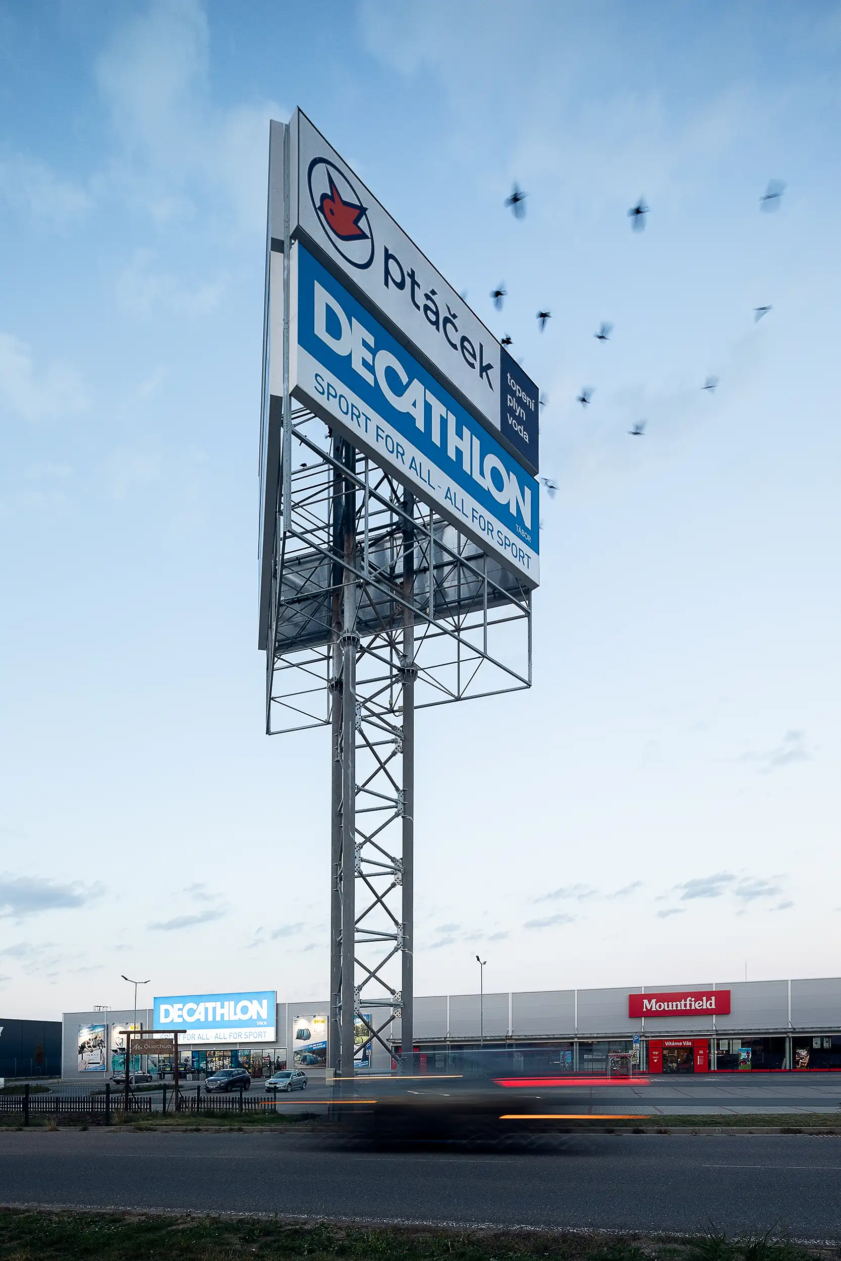 At dusk, I photographed Tabor's retail center Totem Signage, with a flock of birds passing by in motion blur.