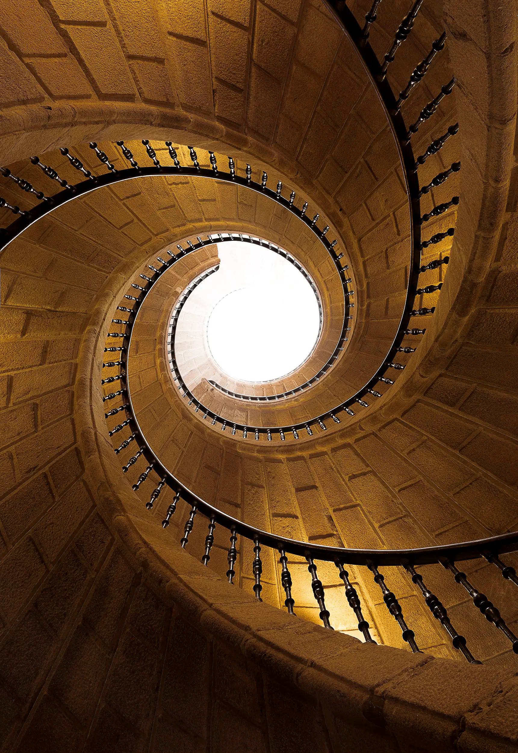 Fine art architecture photography shows three staircases woven into a seemingly endless spiral inside the Museum of Galician People in Santiago de Compostela, shot by architectural photographer Ondrej Hromadko.