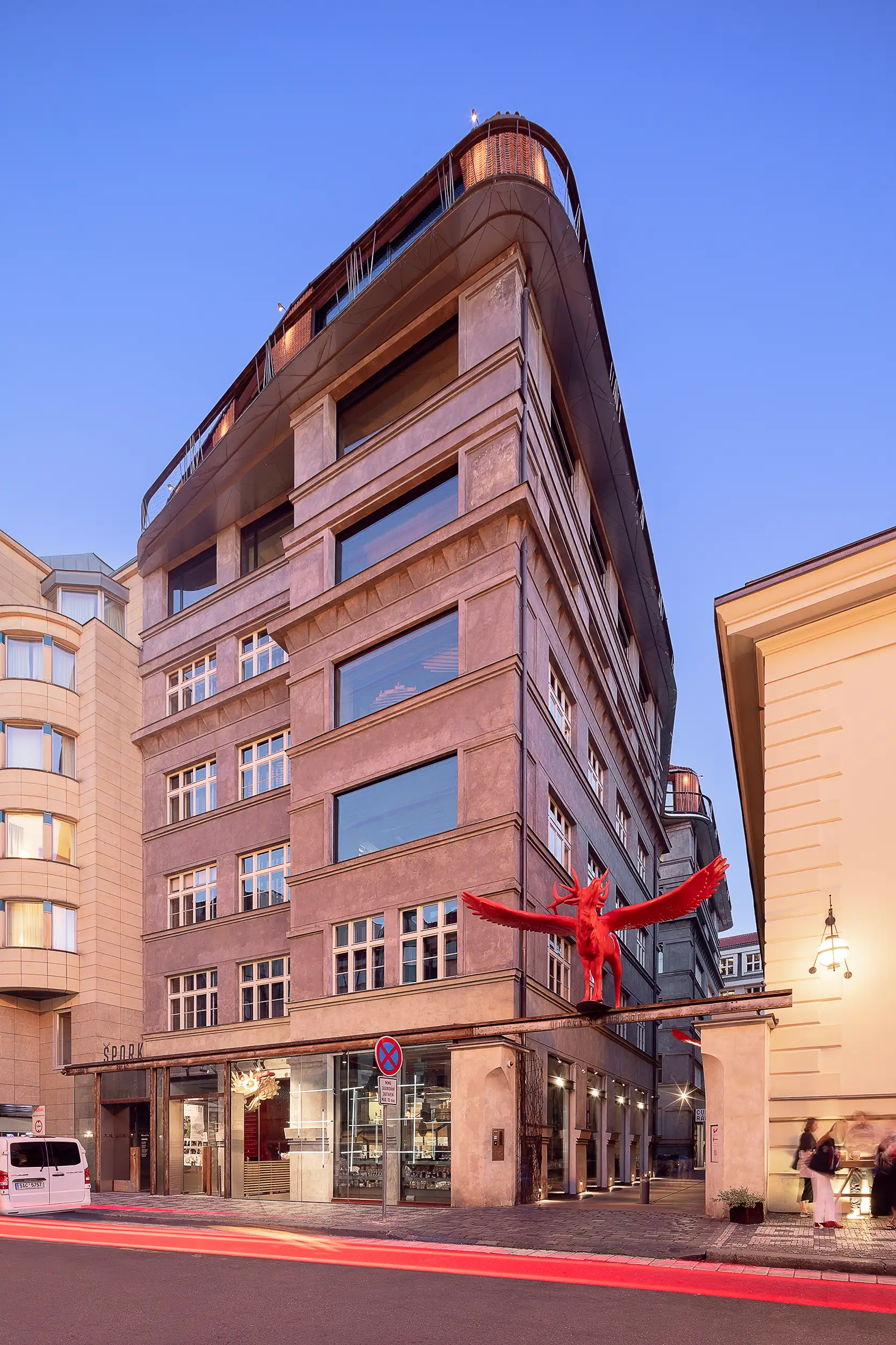 Špork Palace with modern extension captured during the blue hour from V Celnici Street in Prague, in a vertical photo.