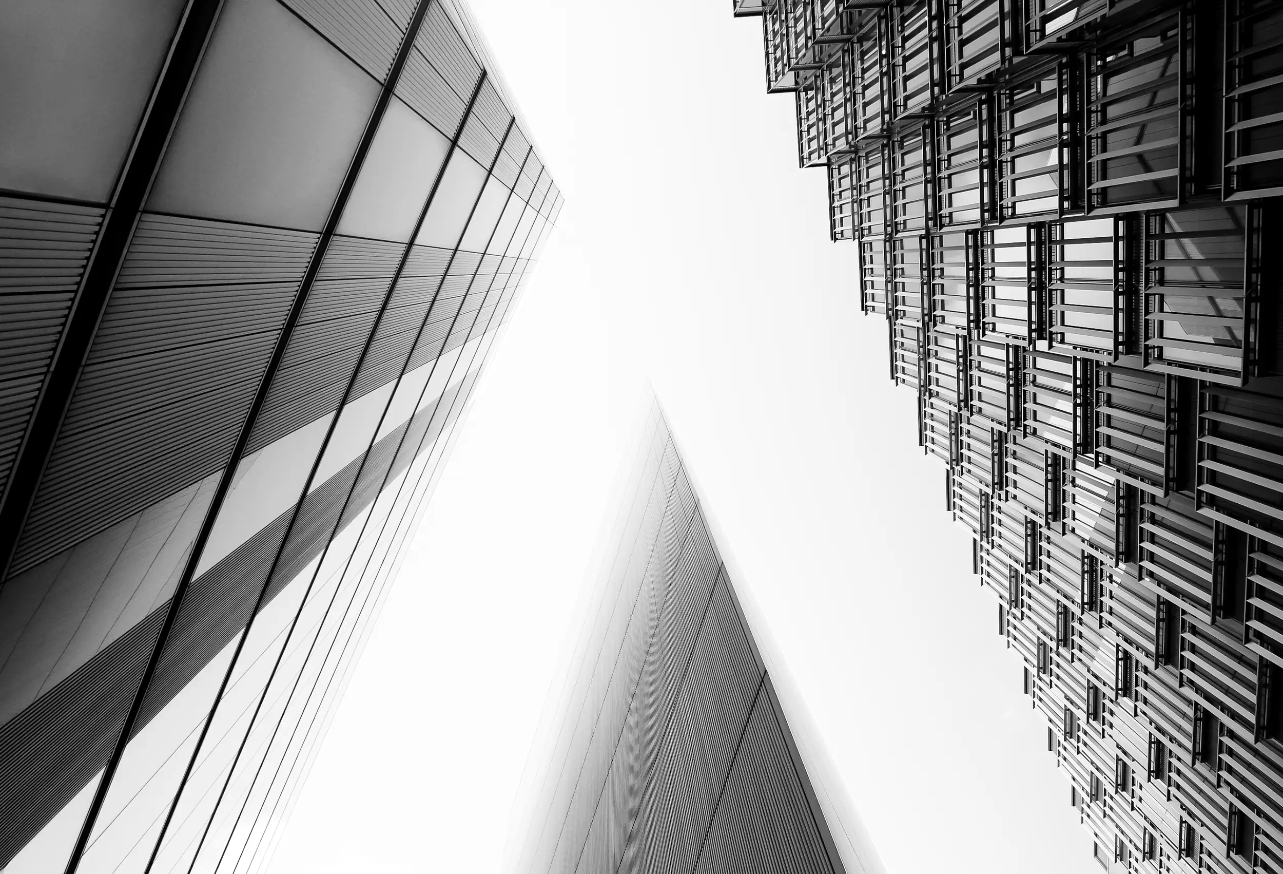 Adjacent facades of PwC buildings in London captured in fine art black and white photography with a look-up perspective by architectural photographer Ondrej Hromadko.