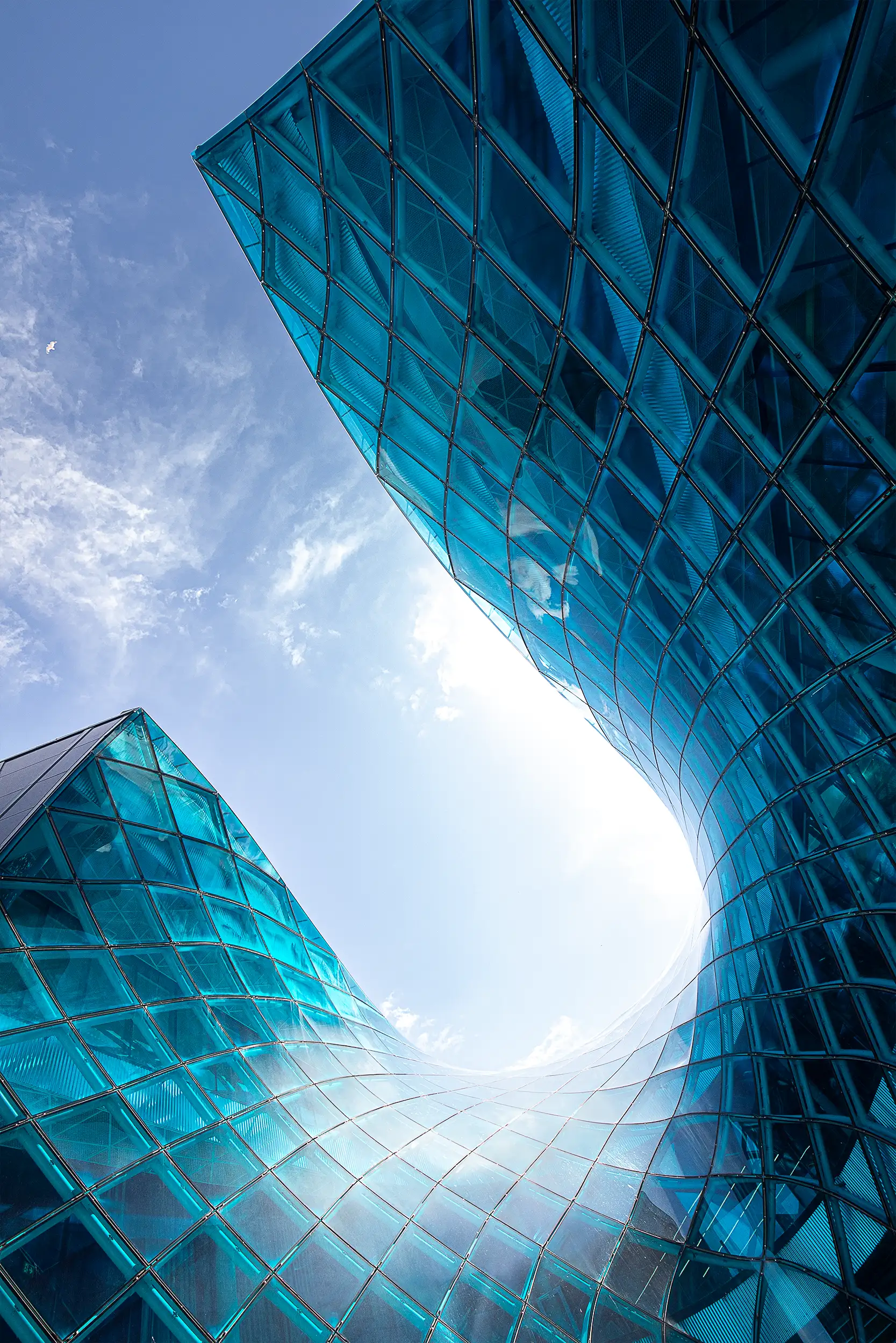 Detail of the modern, fluid architecture of the Emporia shopping centre in Malmö, focusing on the wave-like excursion into the blue glass cladding of the building.