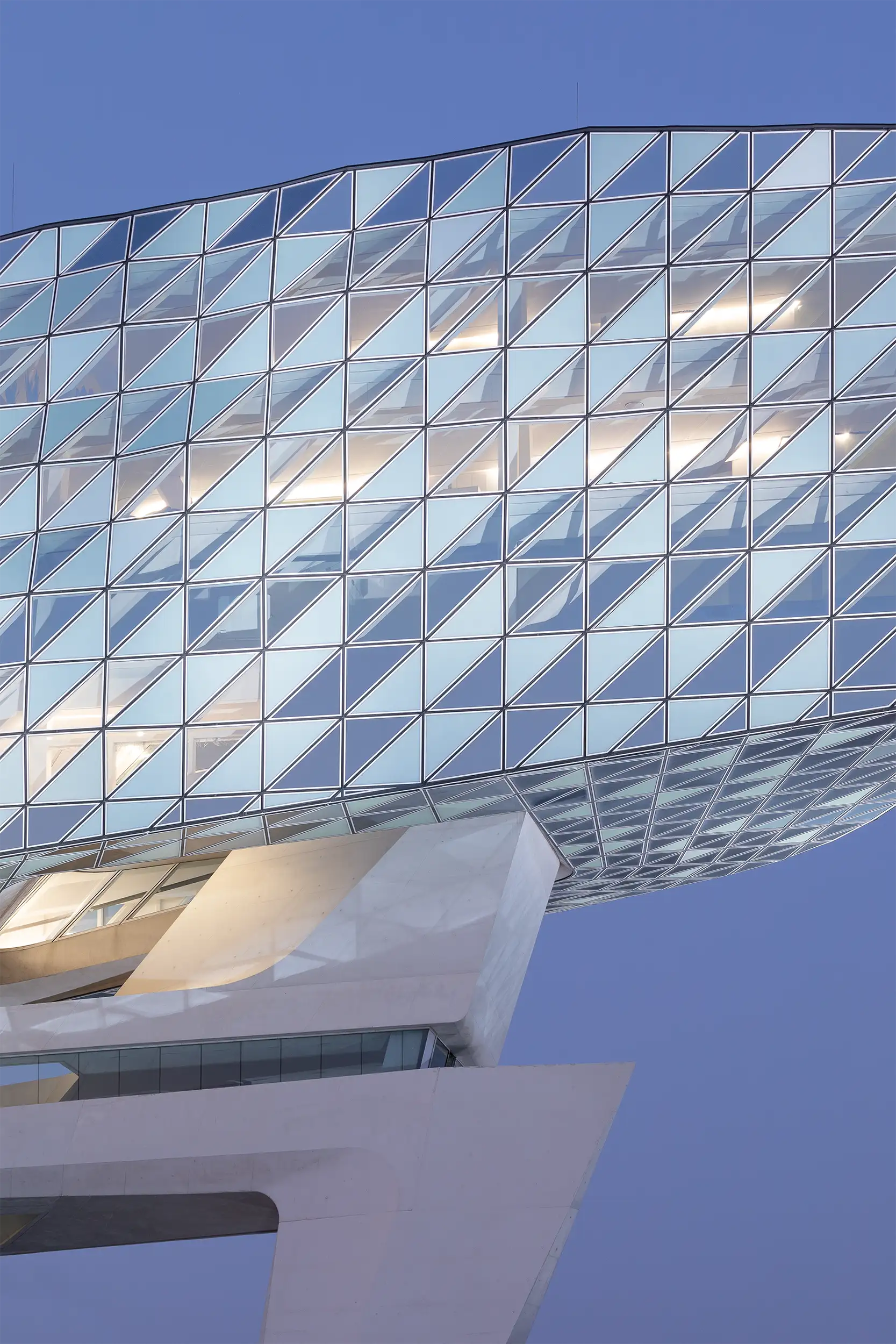 Detailaufnahme der Glasfassade am modernen Anbau des Port House Antwerpen mit transparenten und opaken Elementen.