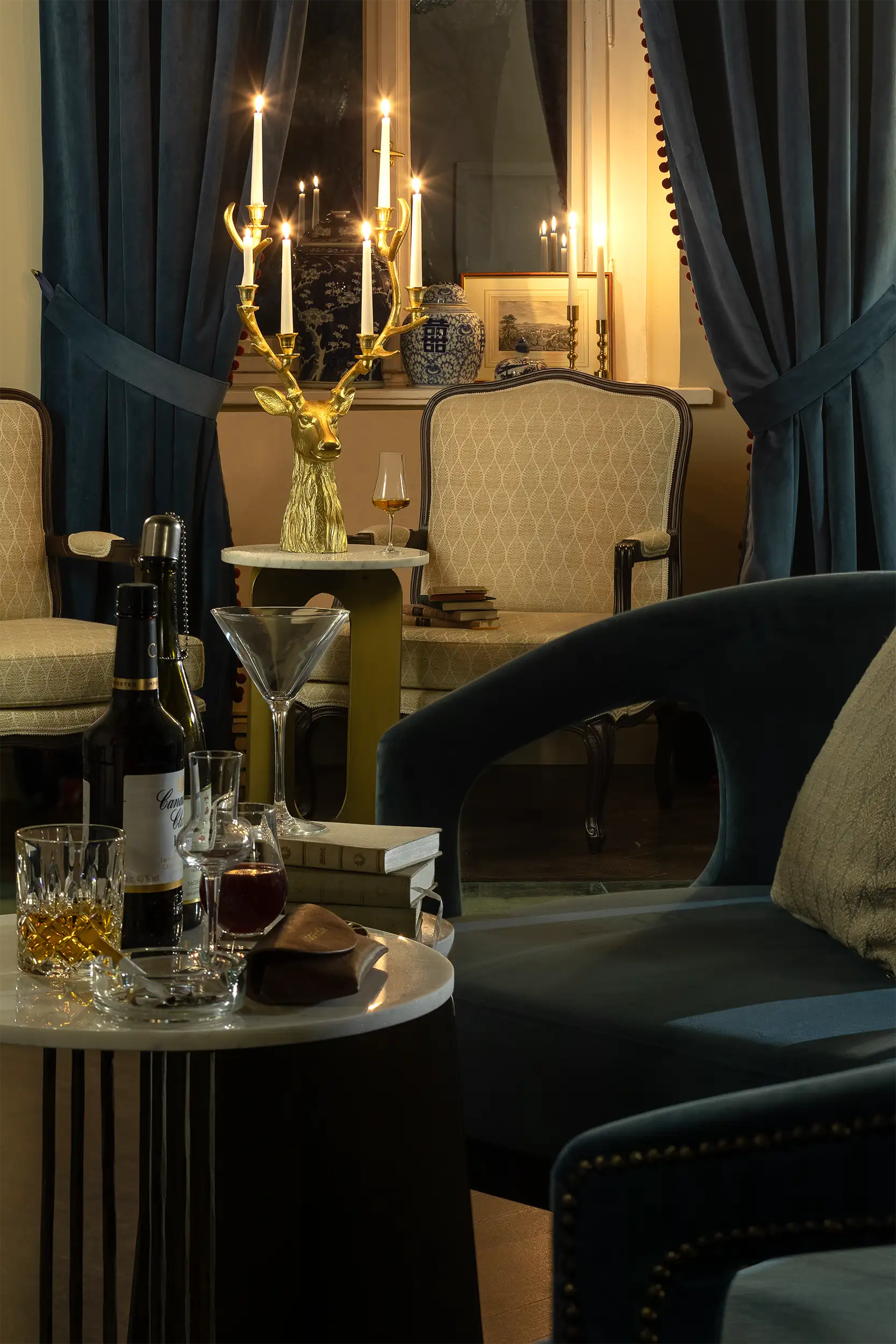 Close-up of a luxurious hotel lounge with candles, a golden antler-shaped candelabra, and a stylish interior.