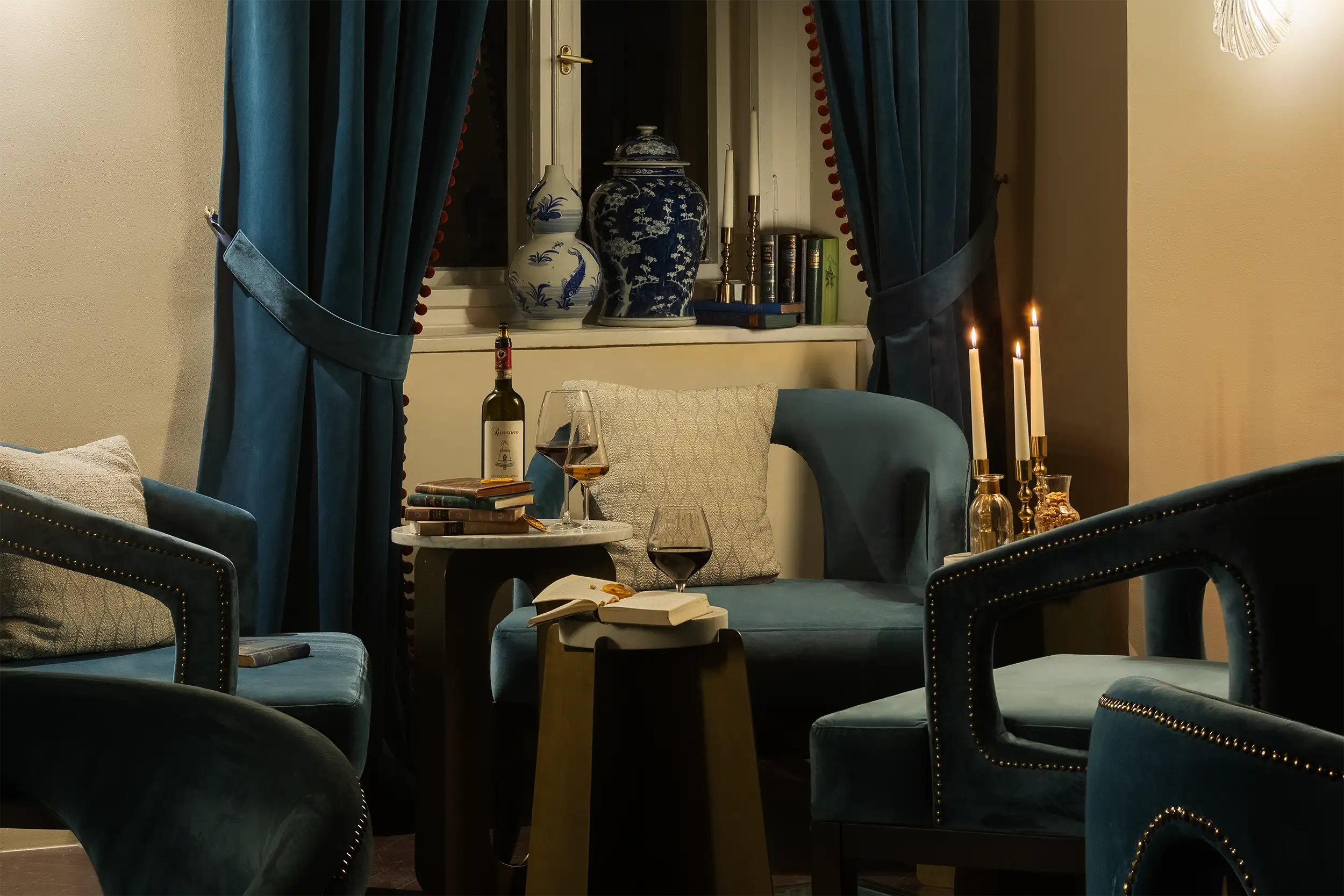 Luxurious hotel lounge with a dark blue velvet sofa, candles on a golden candelabra, and an elegant ambiance.