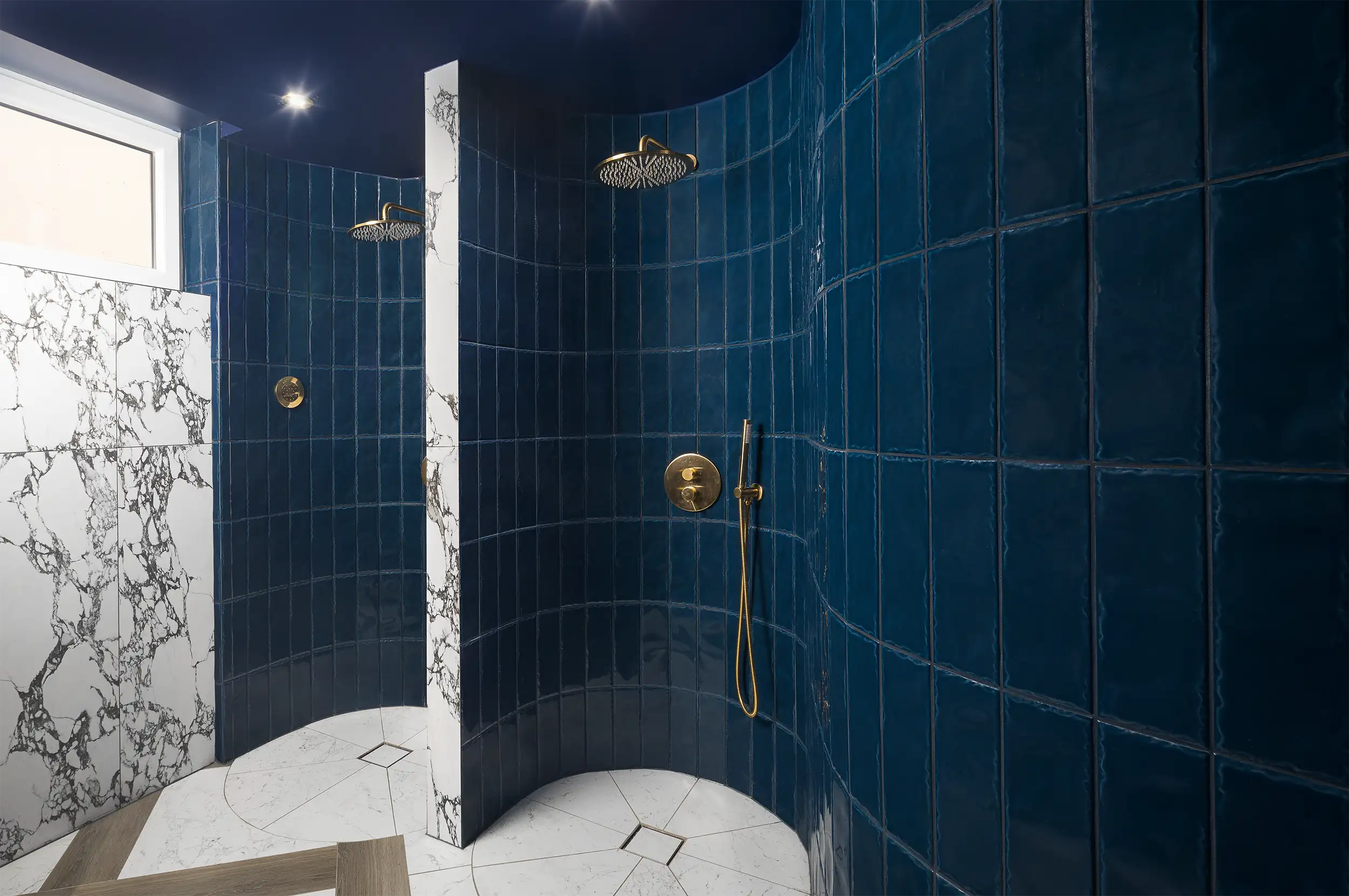 The showers in the hotel's wellness centre are tiled with dark blue tiles, complemented by marble.