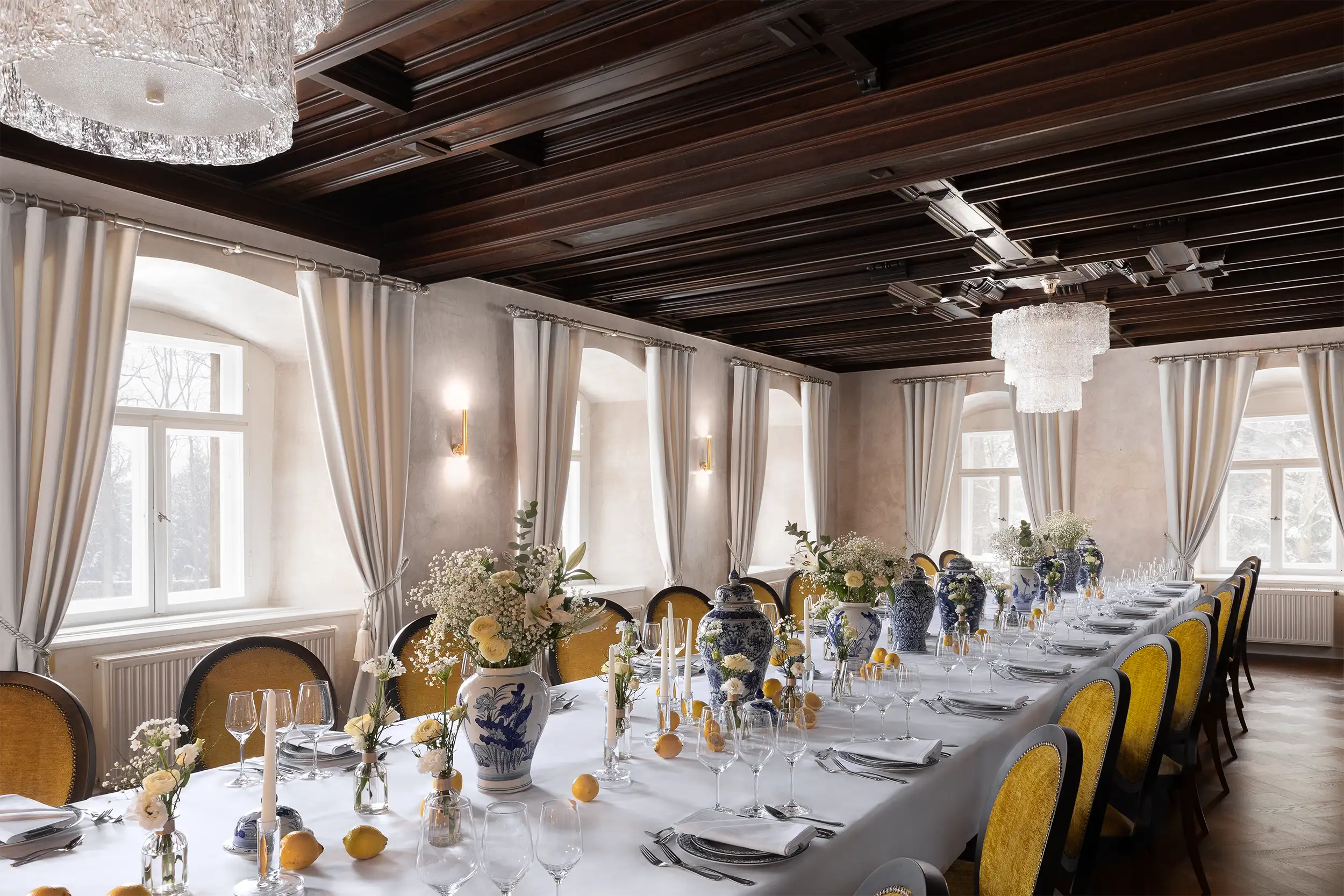 Side view of the hotel castle style wedding table garnished by blue pottery, white flowers and lemons.