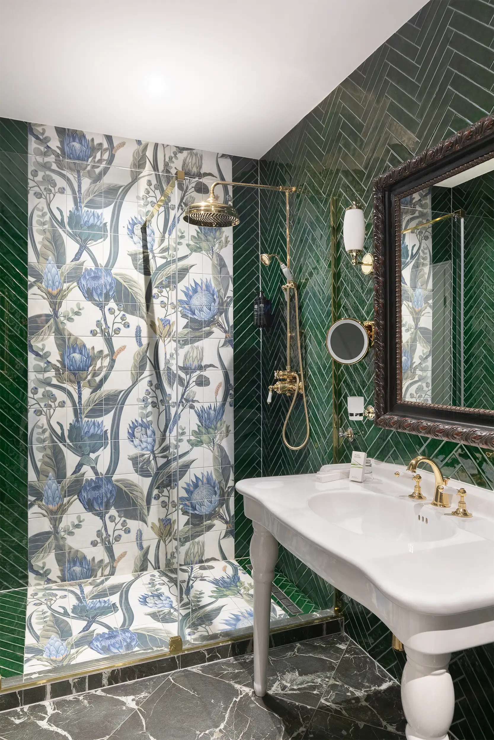Green toned hotel bathroom decorated with flower motifs tiles in combination with diagonal narrow mosaic tiles.