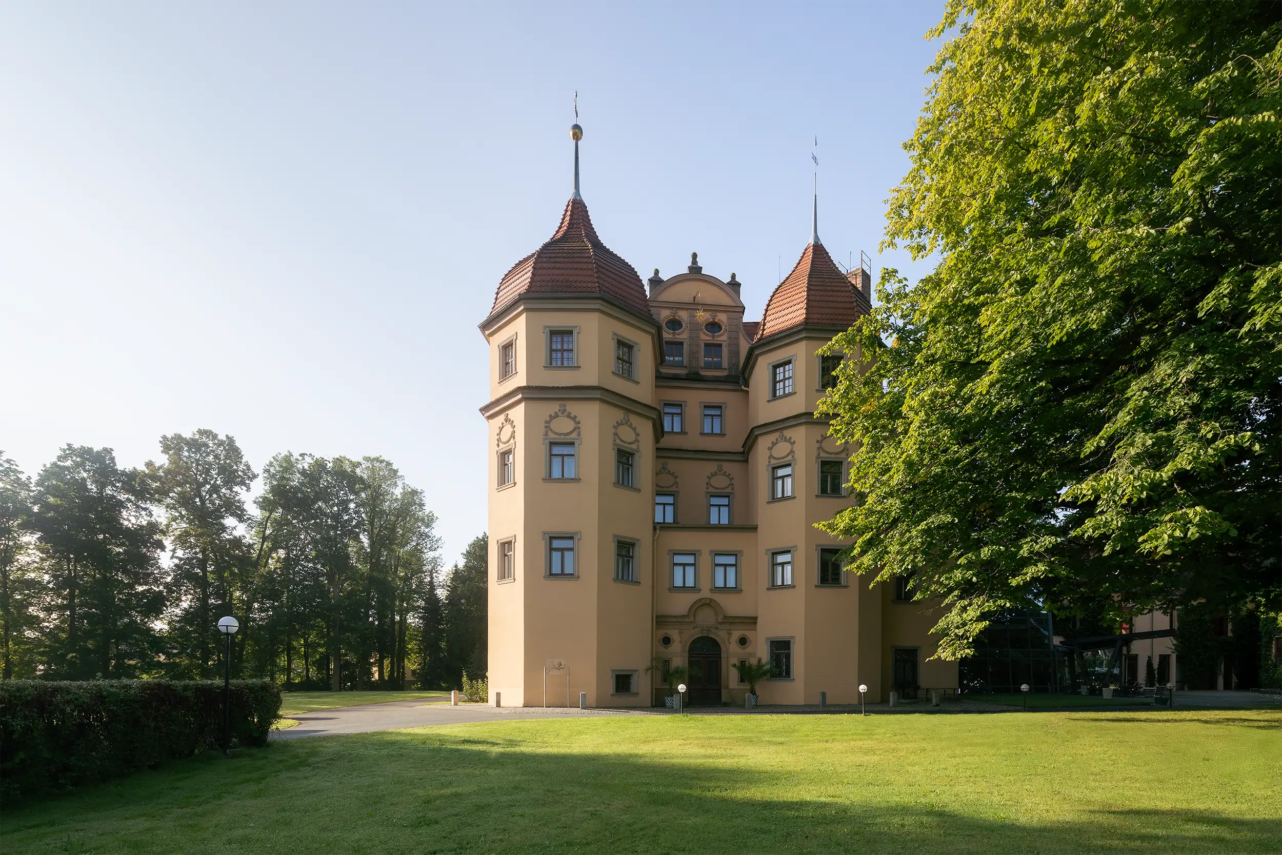 Althörnitz Castle Hotel on a summer morning, surrounded by greenery and soft natural light.
