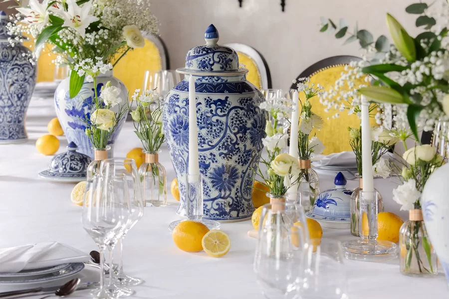 Detail svatebního stolu v italském stylu, zdobeného modrobílým porcelánem, bílými květinami a citróny.