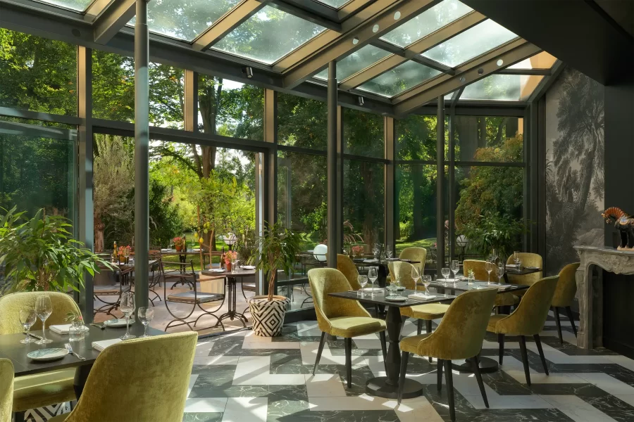 Gläsernes Restaurant Bellinis im Atrium des Schlosshotels Althörnitz mit mediterranem Interieur und Blick in den Schlosspark.